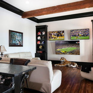 Photo of a large traditional open plan home cinema in New Orleans with white walls, medium hardwood flooring and a wall mounted tv.