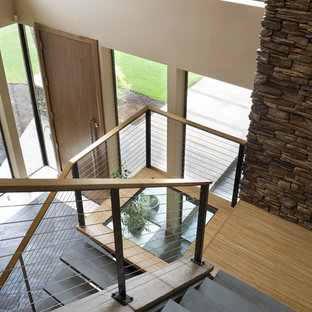 Photo of a contemporary u-shaped wire cable railing staircase in Portland with slate treads and open risers.