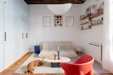 Diseño de sala de estar ecléctica con paredes blancas, suelo de madera en tonos medios, suelo marrón y vigas vistas