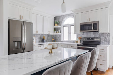 Example of a small country l-shaped medium tone wood floor eat-in kitchen design in New York with an undermount sink, shaker cabinets, white cabinets, quartz countertops, gray backsplash, ceramic backsplash, stainless steel appliances, an island and white countertops