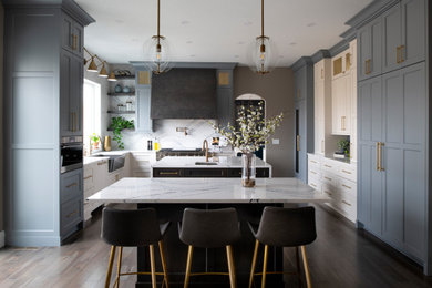 Eat-in kitchen - mid-sized transitional l-shaped medium tone wood floor and brown floor eat-in kitchen idea in Minneapolis with an undermount sink, shaker cabinets, blue cabinets, quartz countertops, white backsplash, quartz backsplash, stainless steel appliances, two islands and white countertops