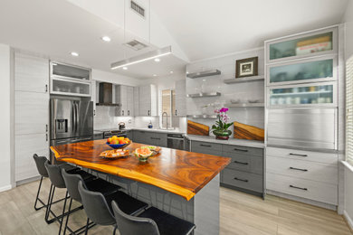 Kitchen - large contemporary vaulted ceiling kitchen idea in Hawaii with a single-bowl sink, flat-panel cabinets, white backsplash, glass tile backsplash and an island
