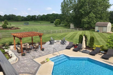 Example of a mid-sized classic backyard concrete paver patio design in Cincinnati with a fire pit and a pergola