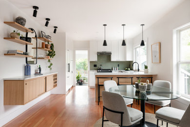 Diseño de comedor de cocina moderno de tamaño medio con paredes blancas, suelo de madera en tonos medios y suelo marrón