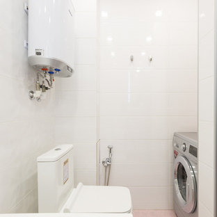 Example of a mid-sized trendy master pink tile and ceramic tile porcelain floor and purple floor bathroom design in Other with flat-panel cabinets, white cabinets, an undermount tub, a two-piece toilet, pink walls, an undermount sink, solid surface countertops and white countertops