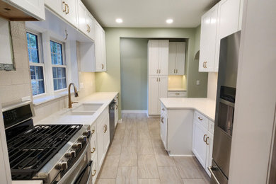 Kitchen - mid-sized craftsman galley porcelain tile and beige floor kitchen idea in Other with an undermount sink, shaker cabinets, white cabinets, quartz countertops, beige backsplash, ceramic backsplash, stainless steel appliances, an island and white countertops