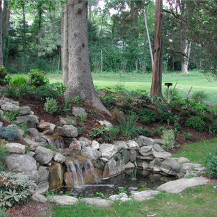 Idées déco pour un grand jardin à la française arrière classique au printemps avec une exposition ensoleillée, des pavés en pierre naturelle et une cascade.