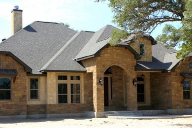 Mid-sized mountain style beige two-story mixed siding exterior home photo in Austin with a clipped gable roof