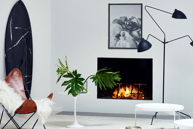 Mid-sized danish formal and open concept light wood floor and beige floor living room photo in New York with white walls, a standard fireplace, a plaster fireplace and no tv