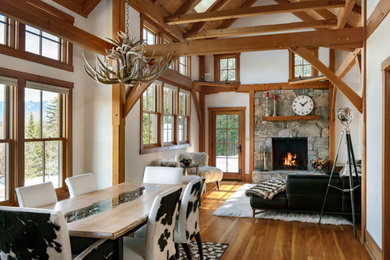 Inspiration for a mid-sized timeless medium tone wood floor dining room remodel in Portland Maine with beige walls, a standard fireplace and a stone fireplace