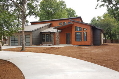 Large trendy one-story mixed siding house exterior photo in Oklahoma City with a shed roof and a metal roof
