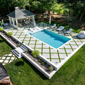 Modern Raised Concrete Pool with White Marble Pavers and Artificial Turf