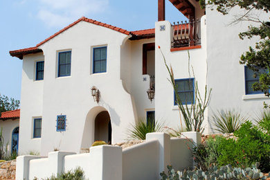 Large southwestern white two-story stucco gable roof idea in Austin