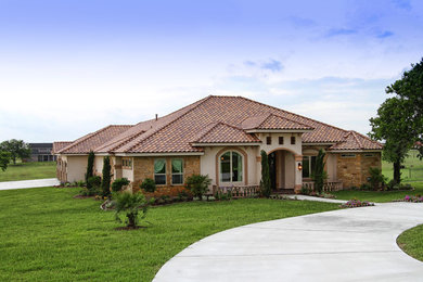 Example of a mid-sized tuscan home design design in Austin