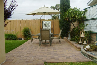 На фото: двор среднего размера на заднем дворе в классическом стиле с покрытием из каменной брусчатки без защиты от солнца с