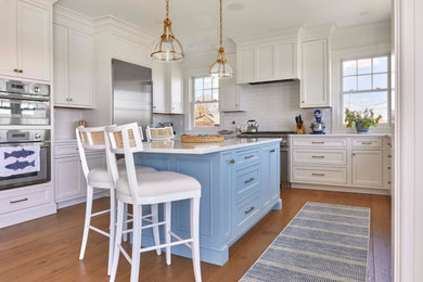 Example of a large beach style eat-in kitchen design in Other with beaded inset cabinets, white cabinets, white backsplash, subway tile backsplash, stainless steel appliances and an island