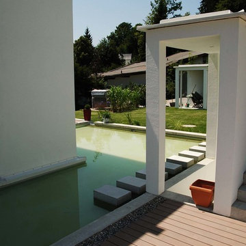 Terrasse aus dunklen WPC Dielen mit moderner Wasserfläche