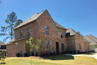 Inspiration for a large timeless brown two-story brick exterior home remodel in Jackson with a shingle roof