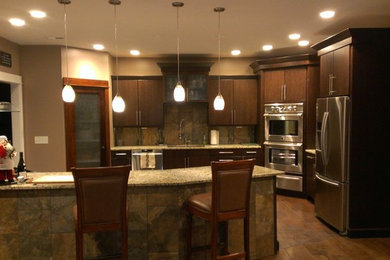 Transitional u-shaped kitchen photo in Huntington with an undermount sink, flat-panel cabinets, dark wood cabinets, granite countertops, stone tile backsplash and stainless steel appliances