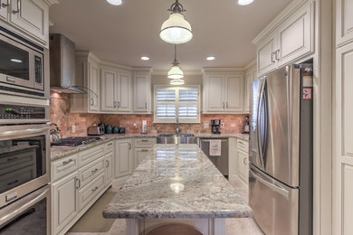 Enclosed kitchen - mid-sized traditional u-shaped porcelain tile and gray floor enclosed kitchen idea in Oklahoma City with a farmhouse sink, raised-panel cabinets, white cabinets, granite countertops, brown backsplash, travertine backsplash, stainless steel appliances and an island