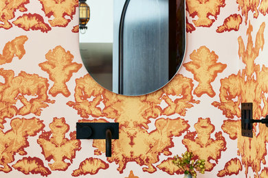 This is an example of a midcentury powder room in San Francisco with yellow walls and a wall-mount sink.