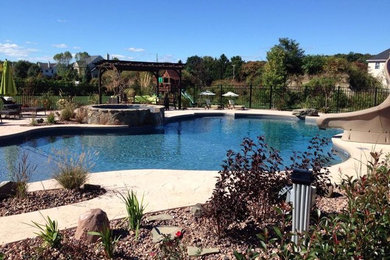 Large backyard custom-shaped natural hot tub photo in New York