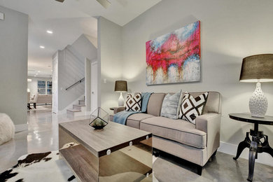 This is an example of a transitional living room in Austin with grey walls and concrete floors.