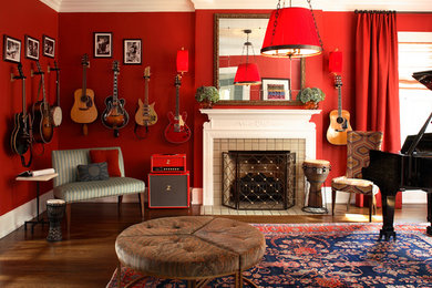 Photo of an eclectic living room in Atlanta with a music area, red walls, dark hardwood floors, a standard fireplace and a stone fireplace surround.