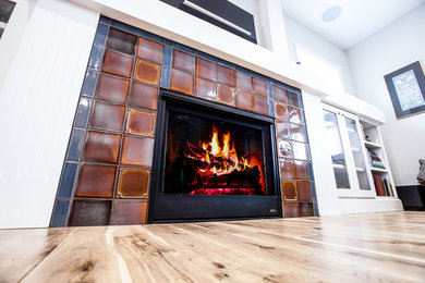 Example of a mid-sized arts and crafts open concept light wood floor and white floor living room library design in Albuquerque with gray walls, a standard fireplace, a tile fireplace and a wall-mounted tv