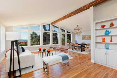 Living room - mid-sized open concept medium tone wood floor living room idea in Portland with white walls