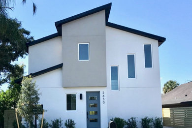 Ispirazione per la facciata di una casa piccola multicolore contemporanea a due piani con rivestimento in stucco, copertura a scandole e tetto nero