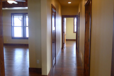 Hallway - rustic dark wood floor hallway idea in Other with beige walls