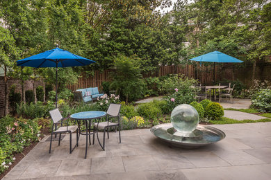 Inspiration for a large traditional backyard patio in DC Metro with natural stone pavers, a water feature and no cover.