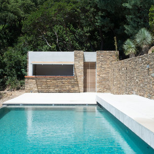 Ejemplo de piscina alargada, mediterránea, grande, rectangular, en patio delantero, con losas de hormigón