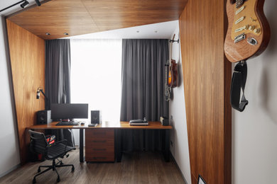 Foto de despacho contemporáneo pequeño con paredes blancas, suelo de madera en tonos medios, escritorio independiente, suelo beige, madera y panelado