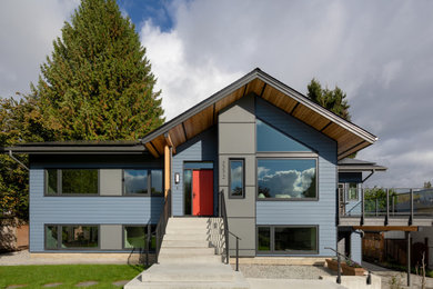 Example of a trendy blue two-story exterior home design in Vancouver with a black roof
