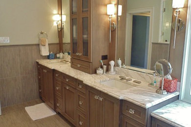 Inspiration for a mid-sized transitional master beige tile and ceramic tile ceramic tile bathroom remodel in New York with recessed-panel cabinets, medium tone wood cabinets, green walls, an undermount sink and soapstone countertops