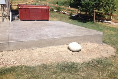 Example of a mid-sized backyard stamped concrete patio design in Denver with no cover