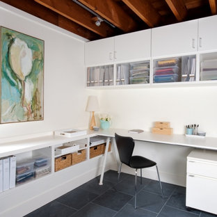 This is an example of a small contemporary study room in San Francisco with white walls, slate floors and a freestanding desk.