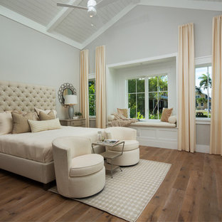 Modelo de dormitorio principal, costero, sin chimenea, con paredes grises y suelo de madera clara