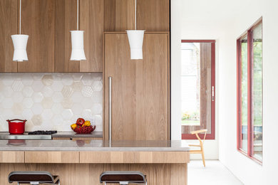This is an example of a contemporary galley eat-in kitchen in Vancouver with concrete benchtops, porcelain splashback, concrete floors and with island.