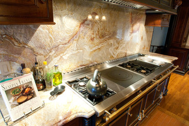Inspiration for a large mediterranean u-shaped light wood floor eat-in kitchen remodel in Philadelphia with an undermount sink, raised-panel cabinets, dark wood cabinets, marble countertops, multicolored backsplash, stone slab backsplash, paneled appliances and two islands
