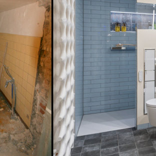Modelo de cuarto de baño con ducha, contemporáneo, de tamaño medio, con armarios con paneles lisos, puertas de armario de madera clara, ducha a ras de suelo, sanitario de pared, baldosas y/o azulejos marrones, baldosas y/o azulejos de cerámica, paredes beige, lavabo sobreencimera, encimera de piedra caliza, ducha abierta y encimeras negras
