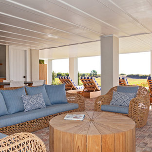 Inspiration for a beach style basement in Charleston with white walls and brick flooring.