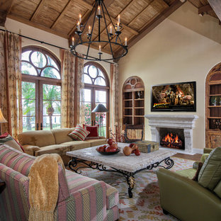 Foto de salón mediterráneo, grande, con paredes beige, chimenea tradicional y televisor colgado en la pared