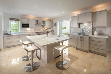 Enclosed kitchen - mid-sized transitional l-shaped travertine floor enclosed kitchen idea in Other with a double-bowl sink, shaker cabinets, beige cabinets, marble countertops, metallic backsplash, metal backsplash, stainless steel appliances and an island