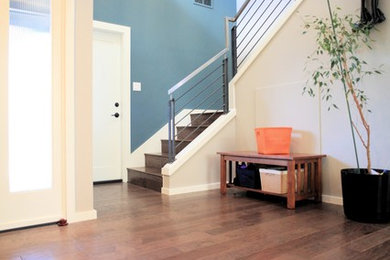 Photo of a large contemporary foyer in Seattle with multi-coloured walls, dark hardwood floors, a single front door, brown floor and a medium wood front door.