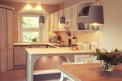 Offene, Kleine Landhaus Küche in U-Form mit Einbauwaschbecken, Kassettenfronten, weißen Schränken, Marmor-Arbeitsplatte, Küchenrückwand in Beige, Rückwand aus Marmor, schwarzen Elektrogeräten, Vinylboden, Halbinsel, grauem Boden und beiger Arbeitsplatte in Sonstige