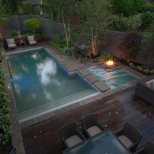 Foto på en mellanstor funkis träningspool på baksidan av huset, med spabad och marksten i betong