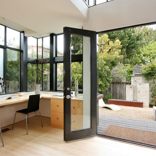 Bild på ett litet funkis arbetsrum, med vita väggar, bambugolv, ett inbyggt skrivbord och beiget golv